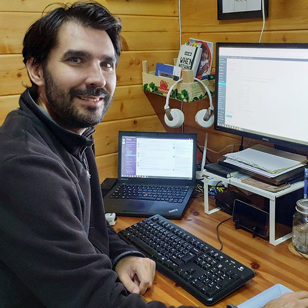 Oscar sonriente sentado frente a su ordenador